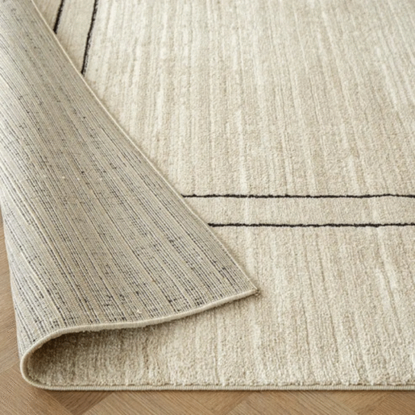 Beige rug with bold black border