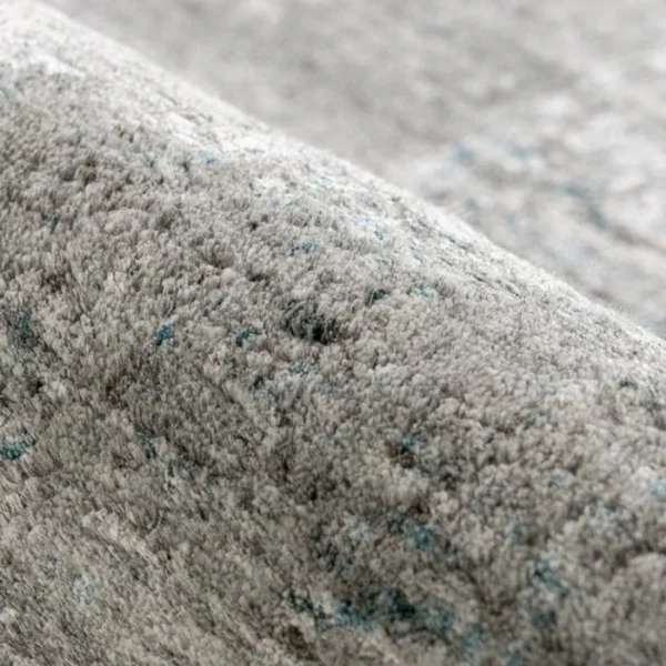 Folded grey abstract rug on floor