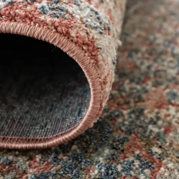 Folded rug showing faded pattern texture