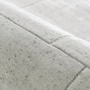Grey textured rug with linear tufting