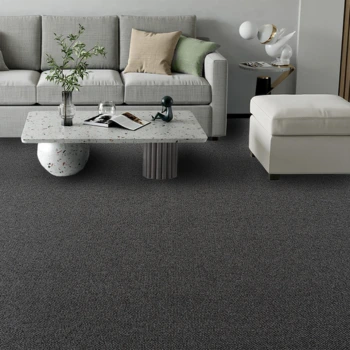 Worker stretching natural wool carpet during fitting